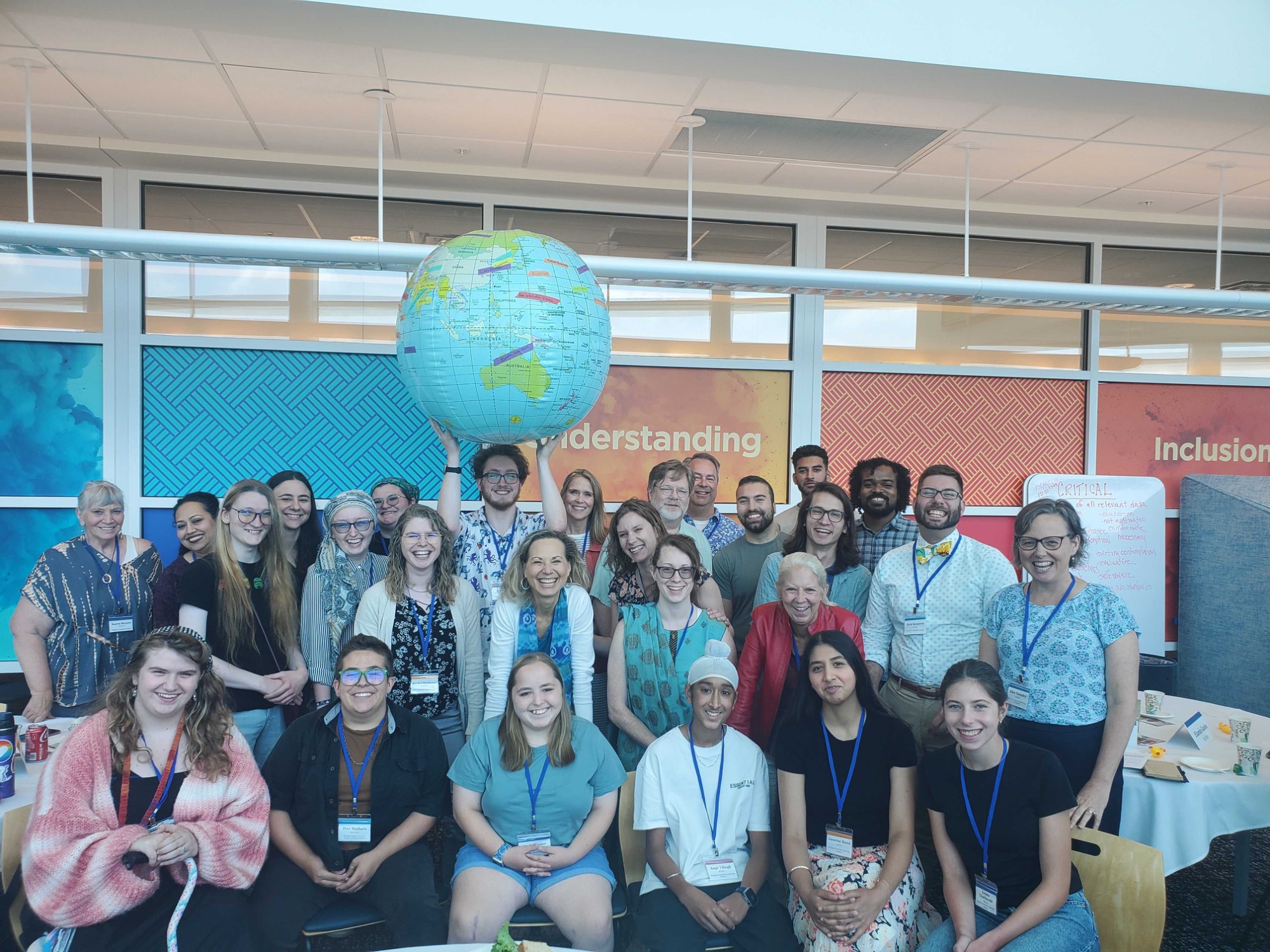 Group of people holding up an inflatable globe